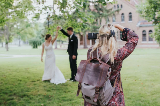 Female wedding photographer holding up a camera